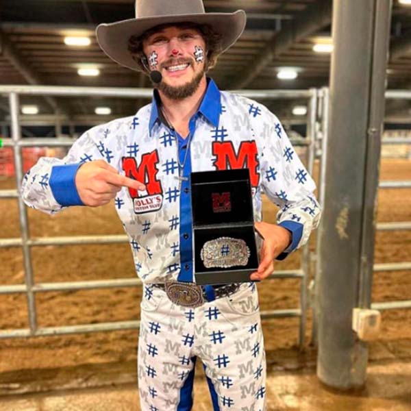 Cowboy holding custom belt buckle.