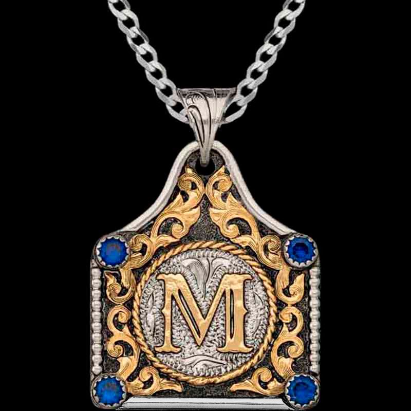 A cow tag necklace with blue zirconias and an M