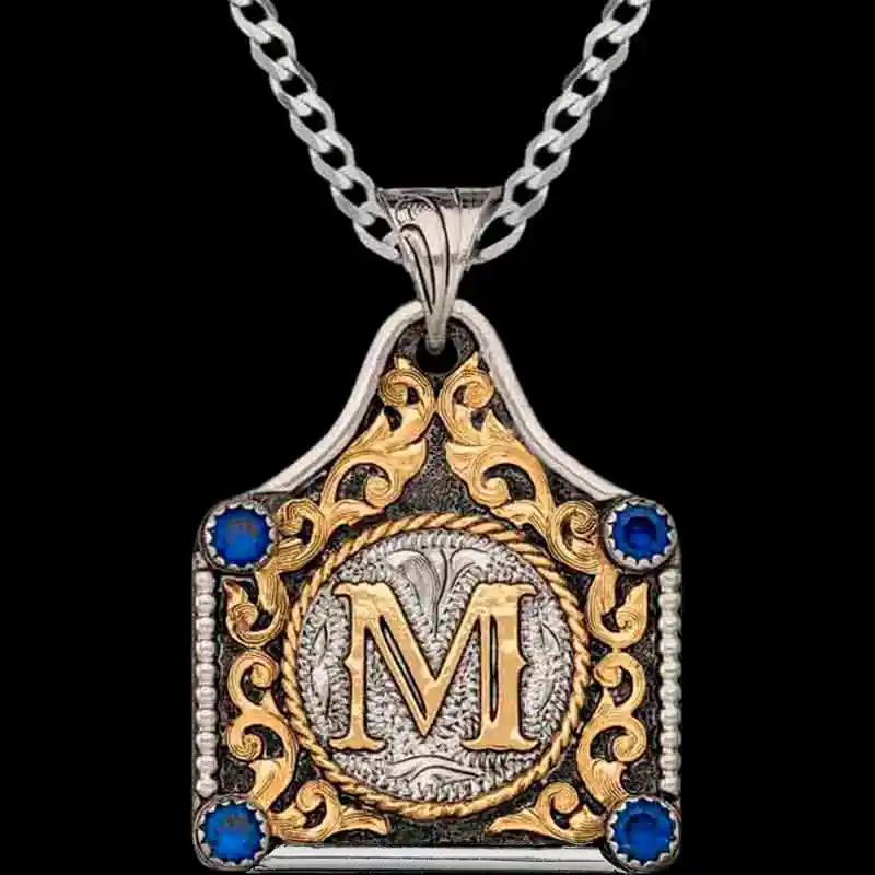 A cow tag necklace with blue zirconias and an M