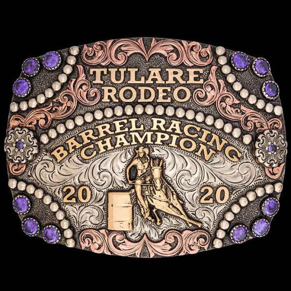 Handcrafted rodeo barrel racing buckle featuring intricate detailing and vibrant colors. The centerpiece showcases a dynamic barrel racing scene with a skilled rider navigating the barrels at high speed. The engraved metalwork captures the energy and exci