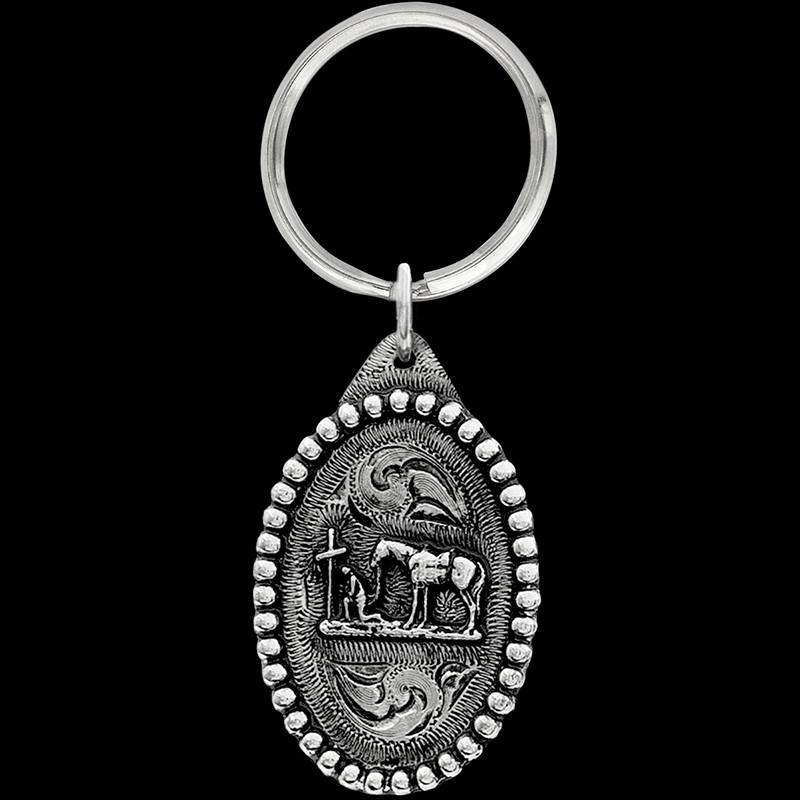 A western keychain with the shape of an oval and a praying cowboy figure