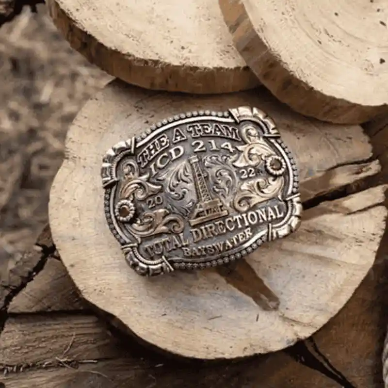 An oil rig western belt buckle on logs